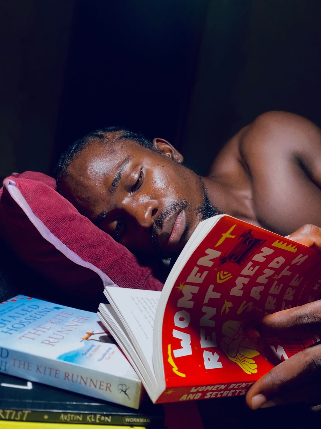 Man reading book in bed, evening setting