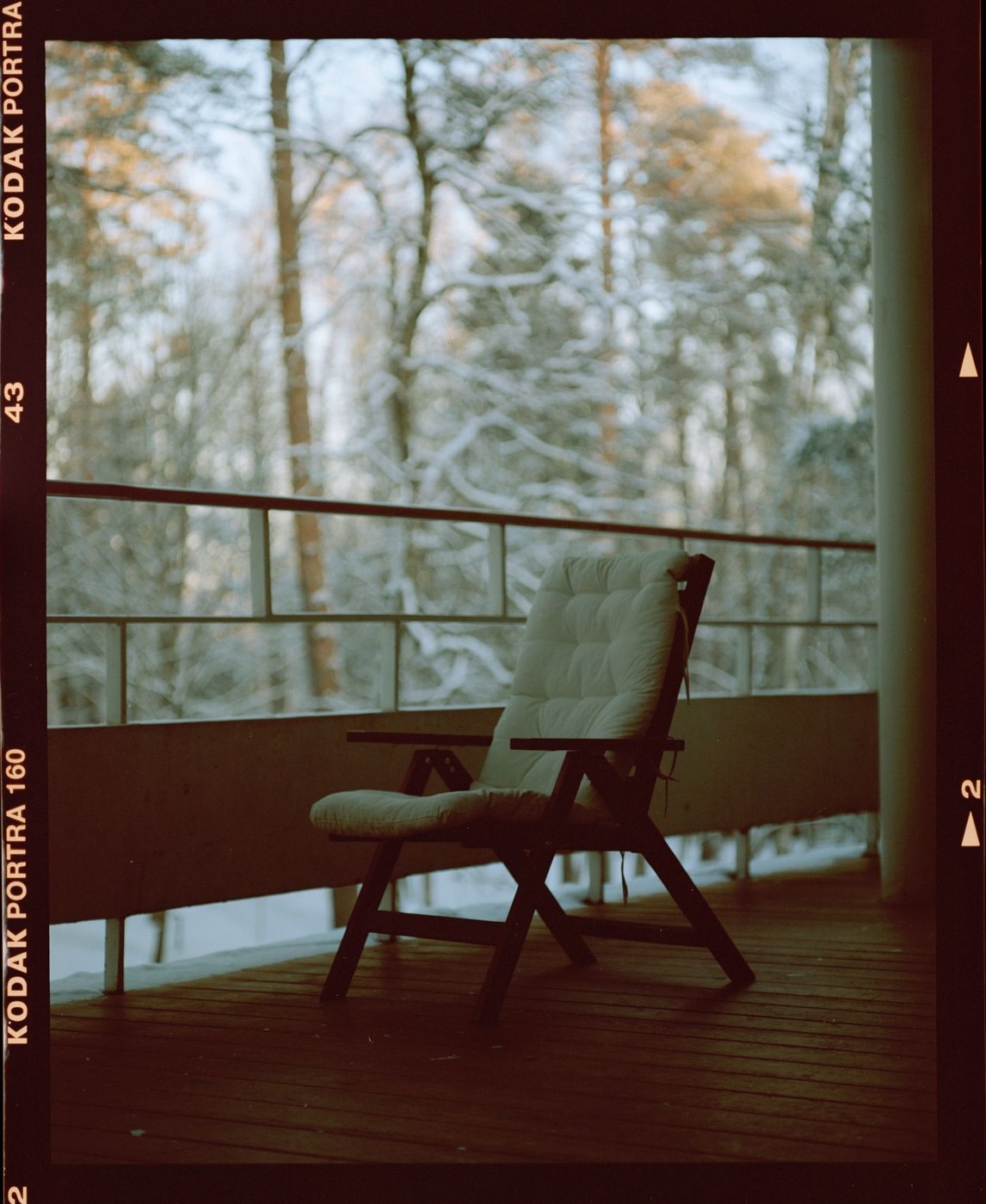 A Film Photo of a Chair Standing on a Balcony