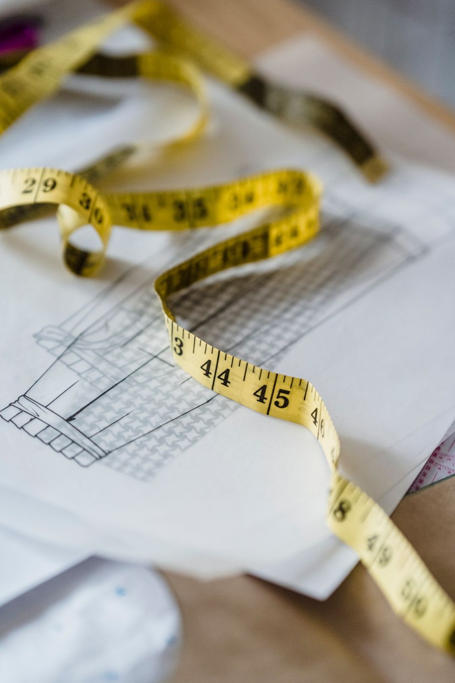 A tape measure resting on a drawn floor plan