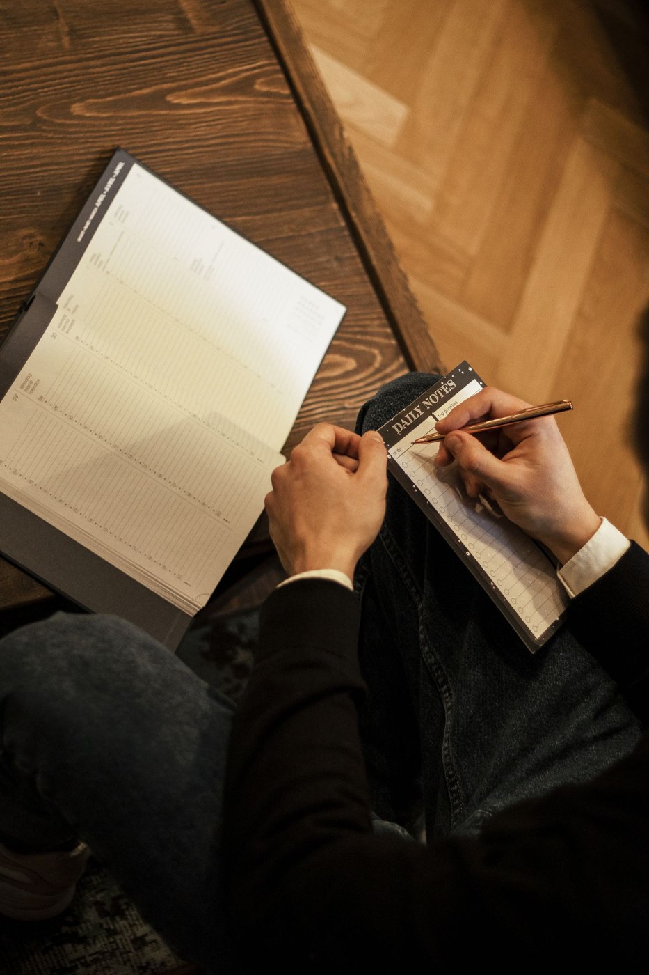 A person writing in an open notebook