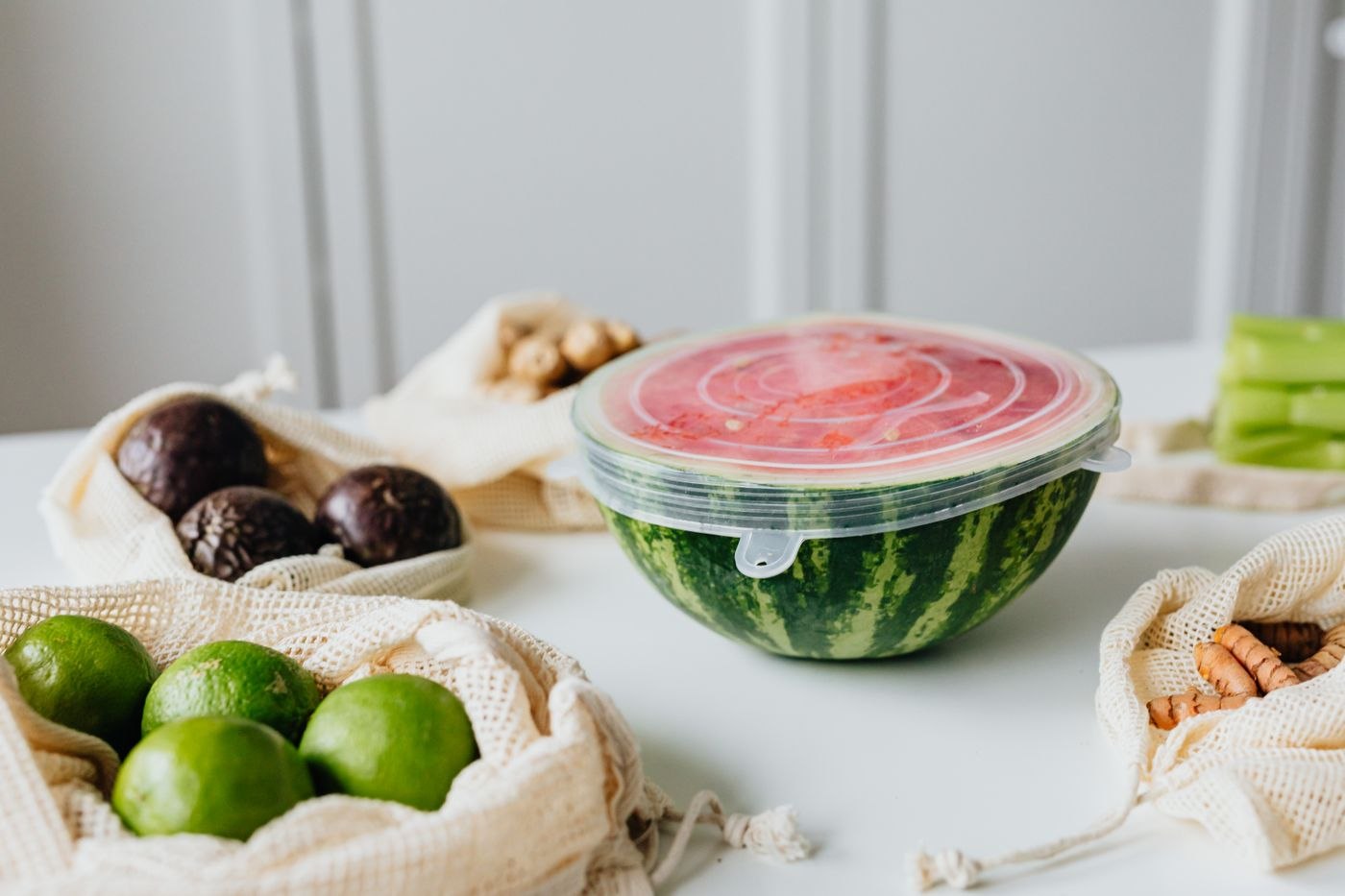 A watermelon half covered with a fitted food-storage lid