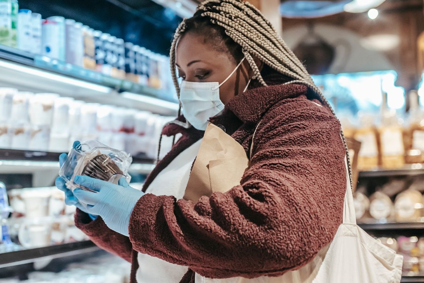 A shopper reading the label on a packaged item